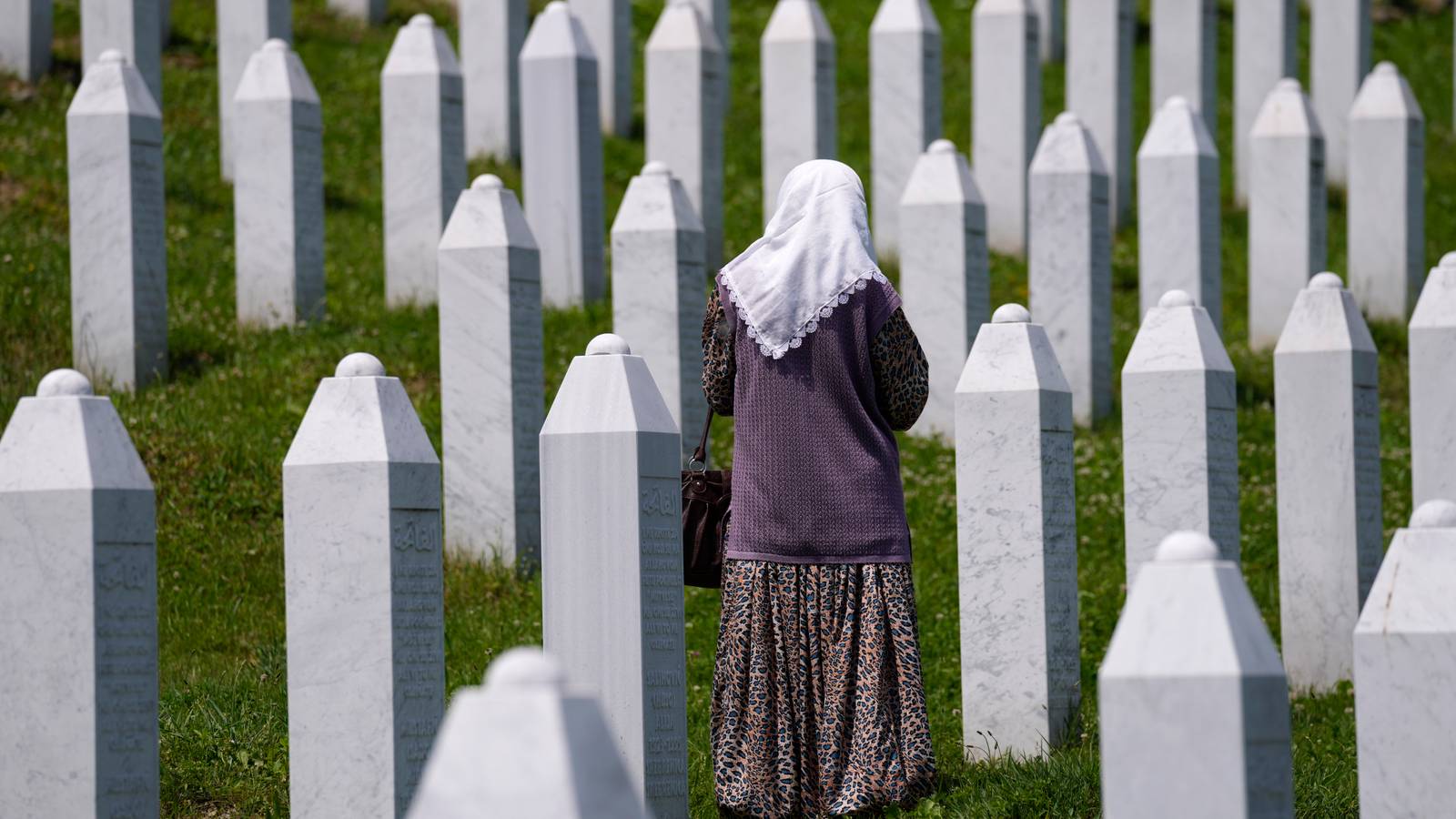 A woman walks stands among the graves of victims of the Srebrenica massacre in Bosnia.
